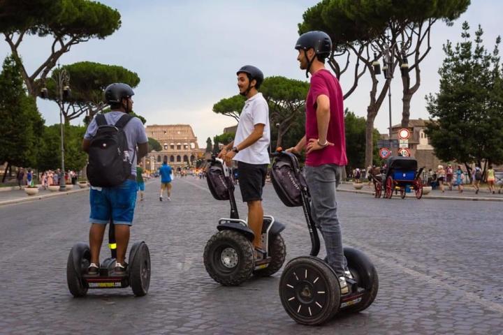 boys riding segways in front of the Colosseum