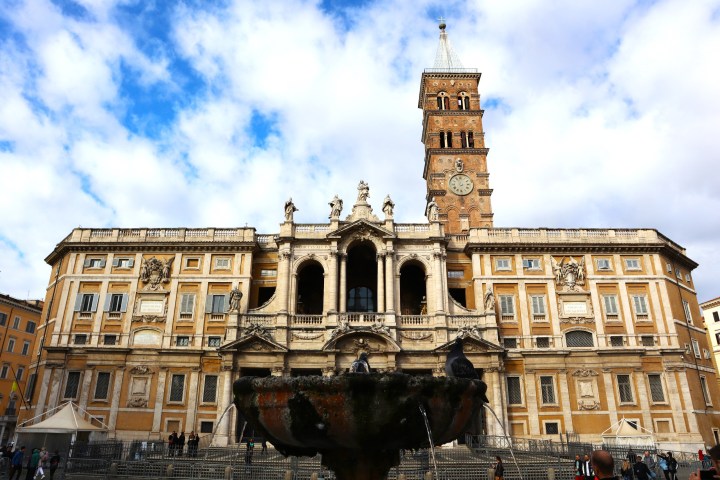 Historic building with ornate facade and clock tower under a cloudy sky.