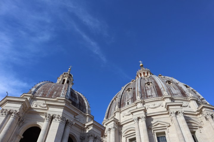 View of two domes with architectural details under a clear blue sky.